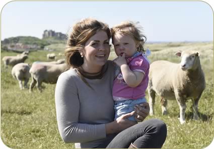 Christina and her daughter Henrietta with Bamburgh Castle in the background